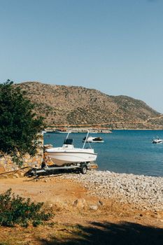 Tranquil scene of a boat by the rocky shore in Greece under clear skies.