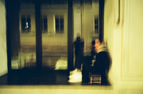 Free Abstract blurred image of person sitting by window at night with urban backdrop. Stock Photo