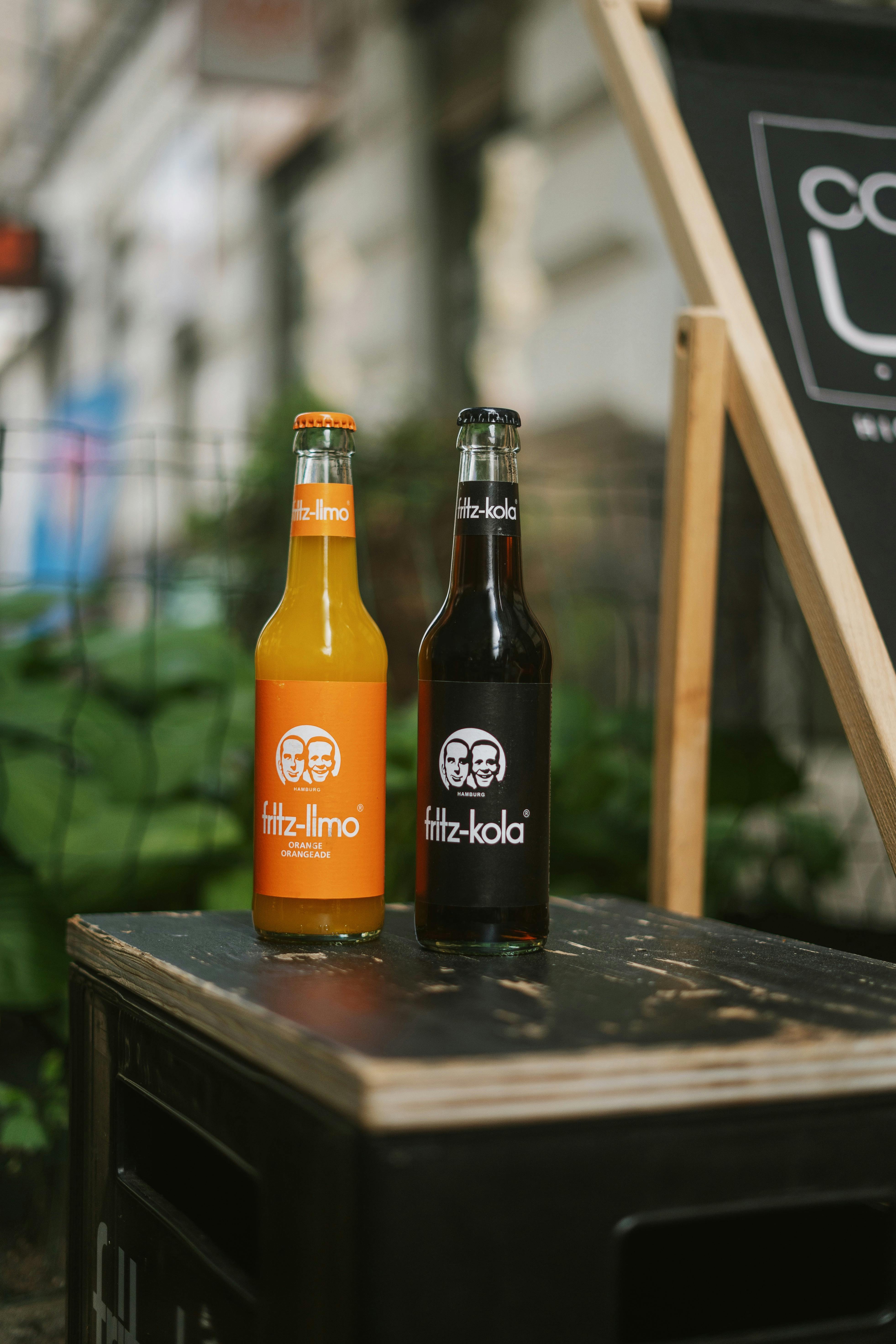 Vibrant soda bottles on a table outdoors showcasing colorful design and branding.