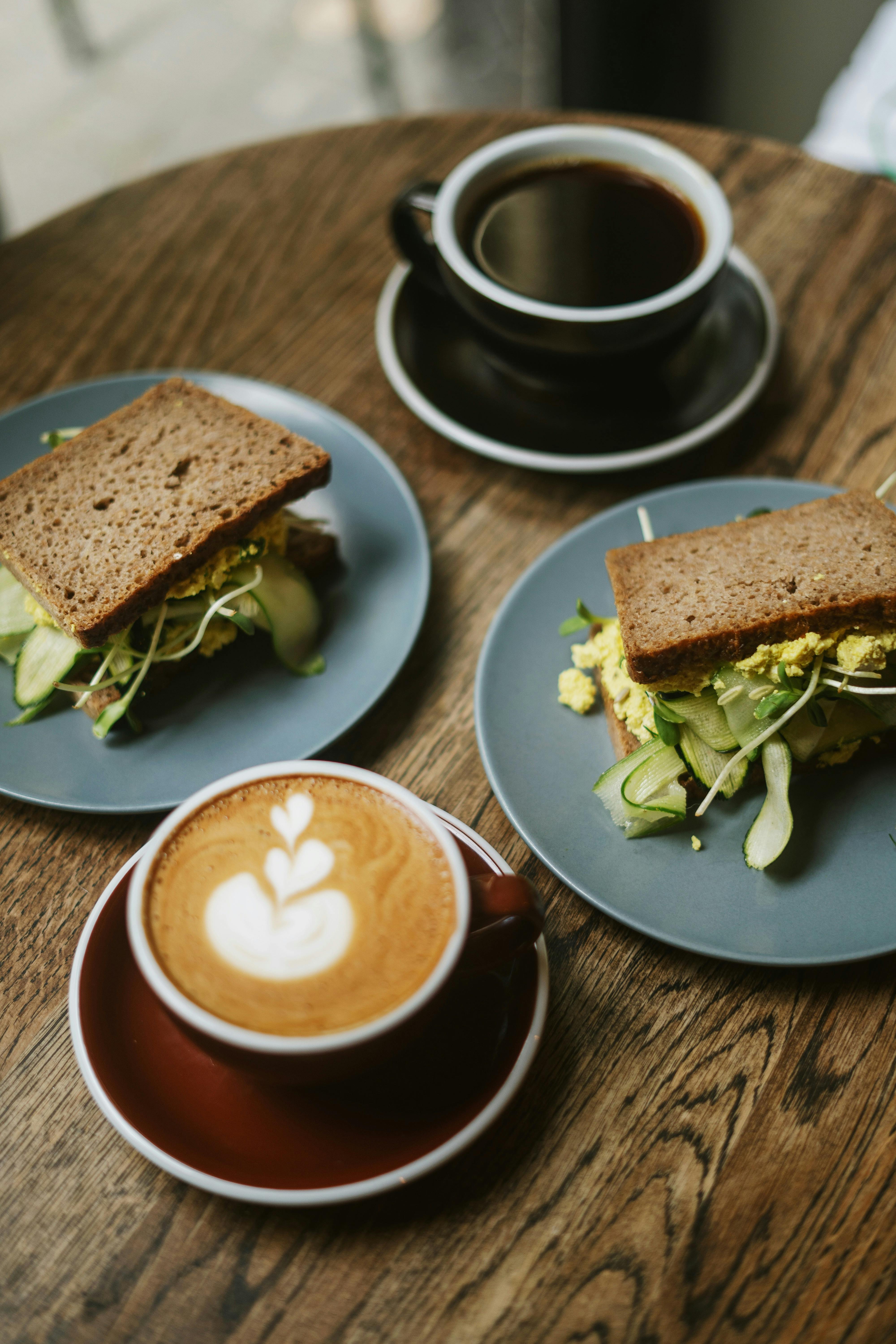Enjoy a hearty breakfast with rye bread sandwiches and coffee, perfect for a cozy morning.