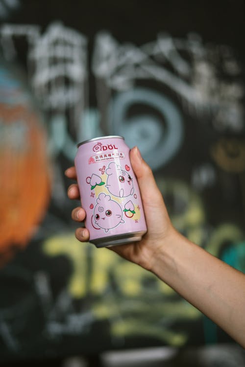 Soda in a Can held by a Person