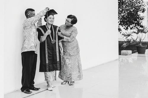 A Mother and Father Standing Beside Daughter During Graduation