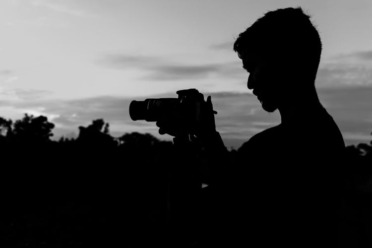 Silhouette Of Man Holding Camera