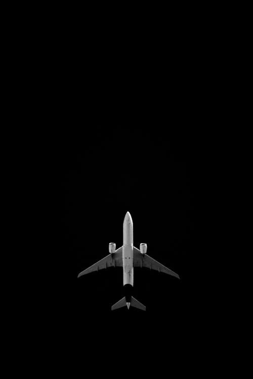 Low Angle Shot of a Flying Plane against the Night Sky 