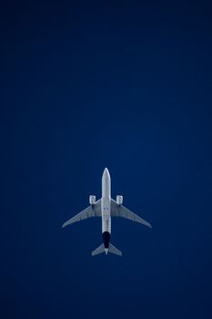 Airplane captured mid-flight soaring through a vibrant blue sky, showcasing modern aviation technology.