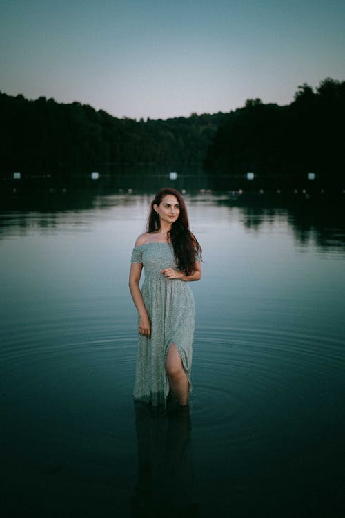 Woman in Gray Dress Standing on Water