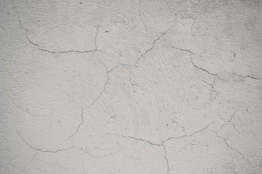 Close-up of a cracked concrete wall showing texture and imperfections.