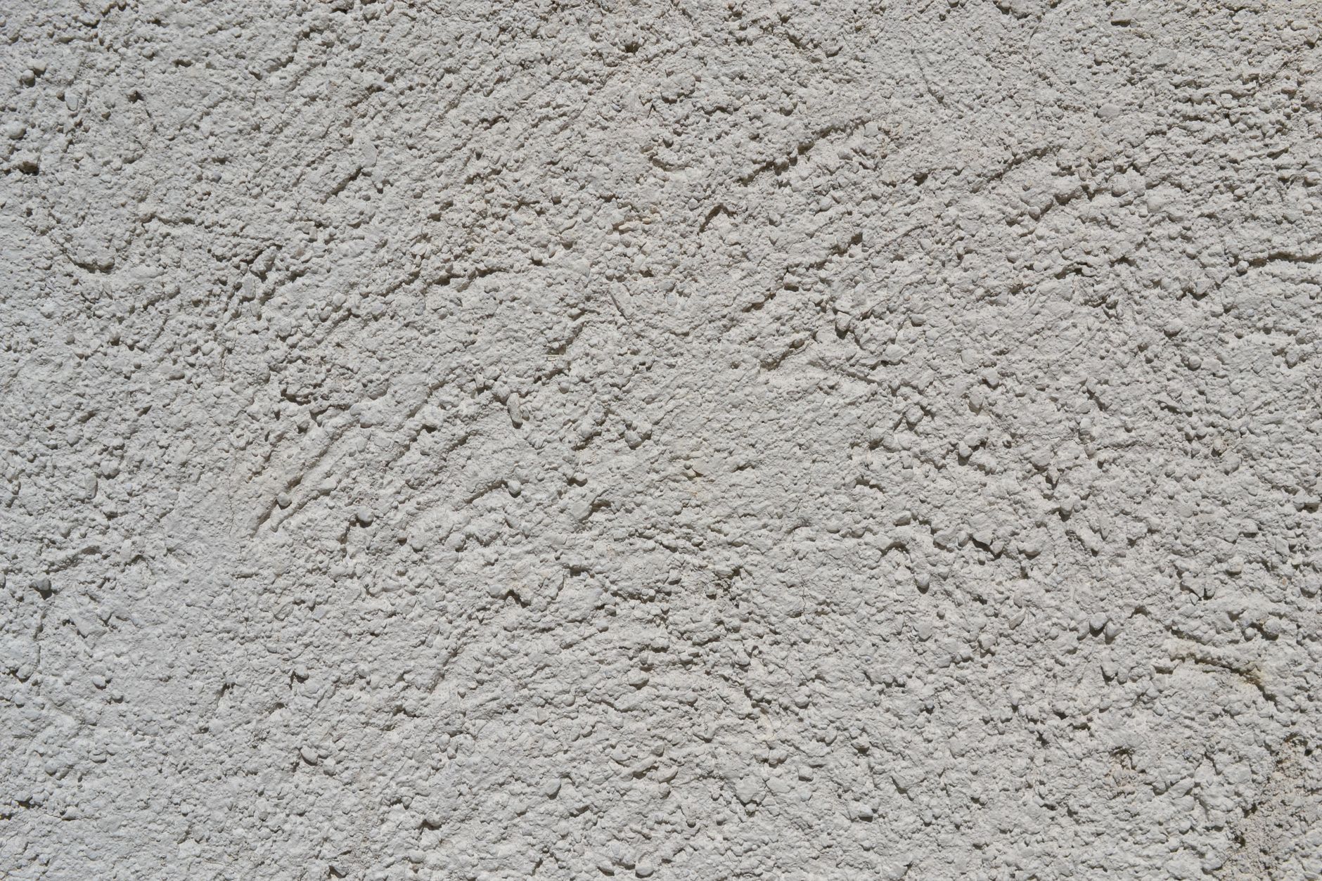 Close-up of a light gray stucco wall texture, ideal for backgrounds.