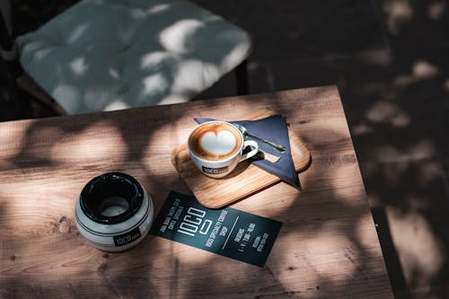 Free A Brochure Near a Coffee Cup on Wooden Table Stock Photo