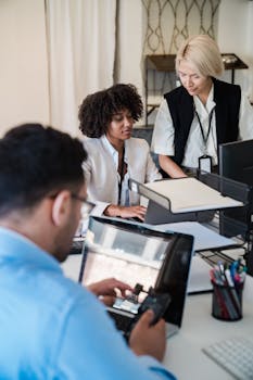 A diverse group of professionals working together in a contemporary office setting, showcasing teamwork and collaboration.
