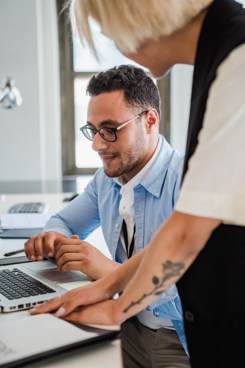 Free Two professionals collaborating in a modern office setting, engaged in project discussion. Stock Photo