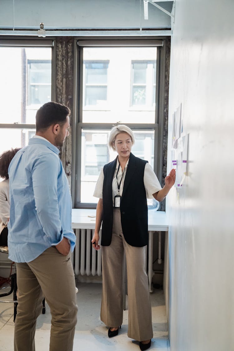 Boss Talking To Employees During Planning Meeting At Office