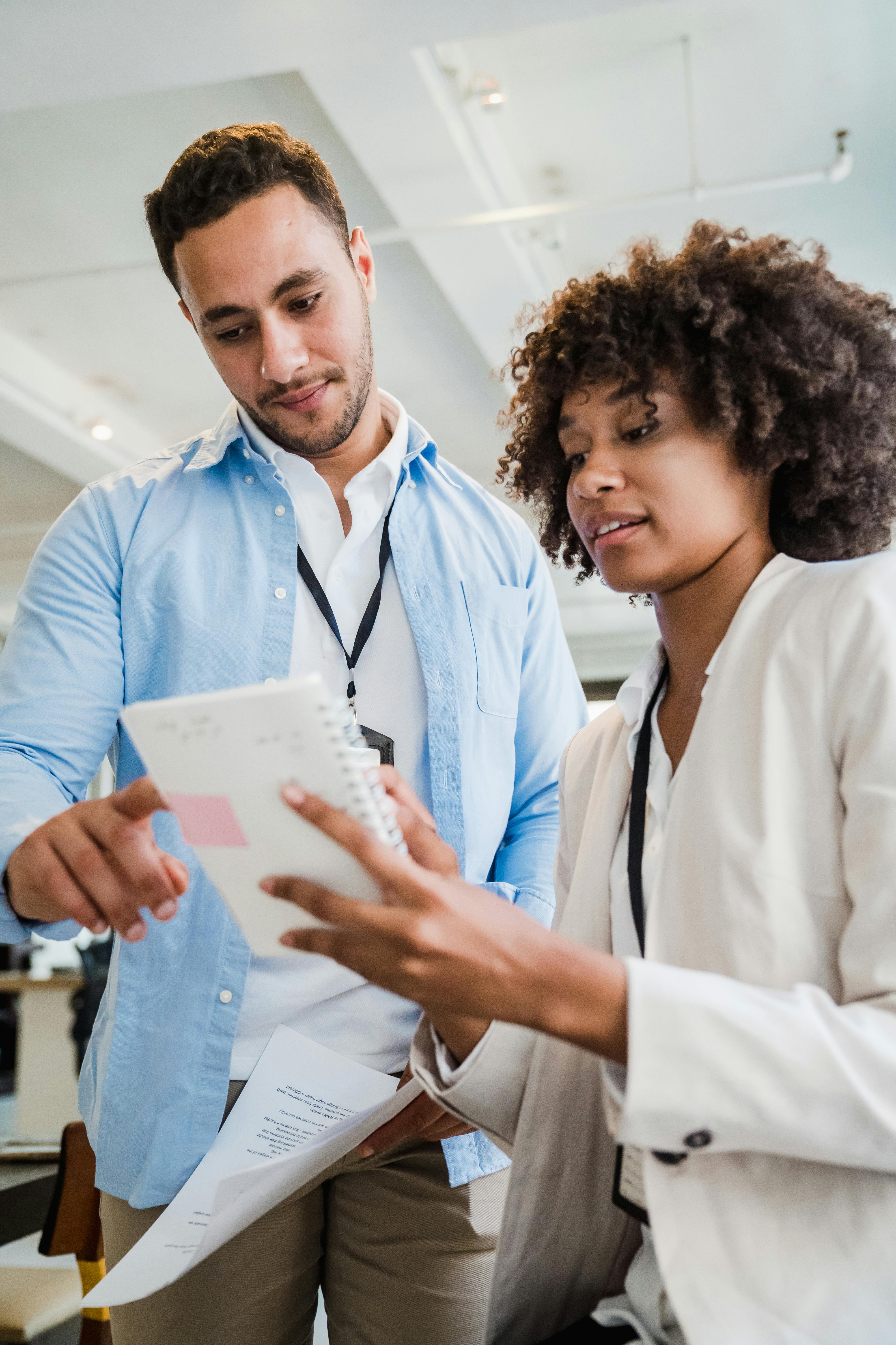 Two professionals collaborating in a modern office setting, focusing on a document.
