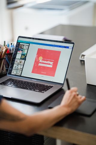 Laptop with a red promotional ad layout open in a design app