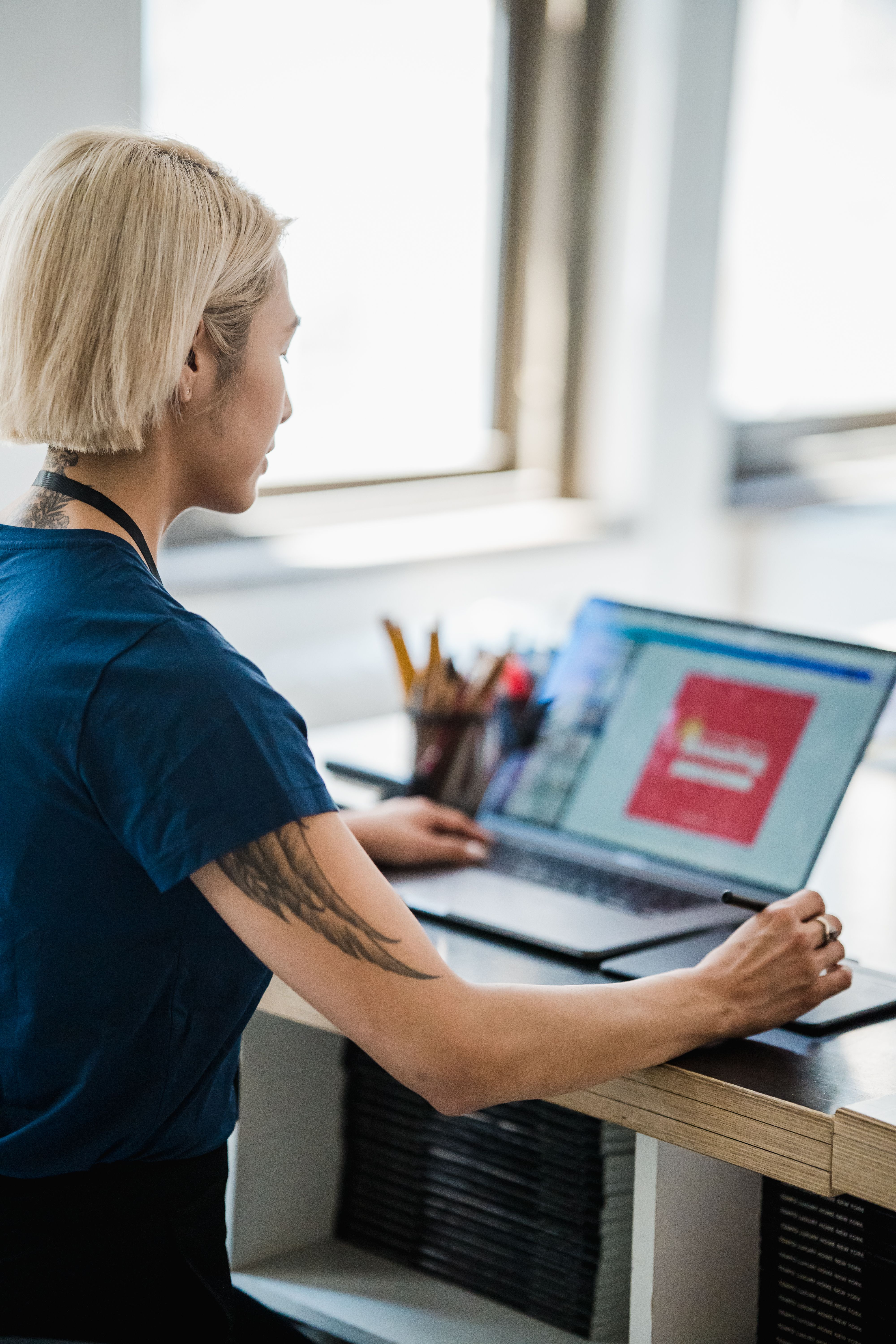 Designer working at a laptop and drawing tablet, by Mizuno K on Pexels