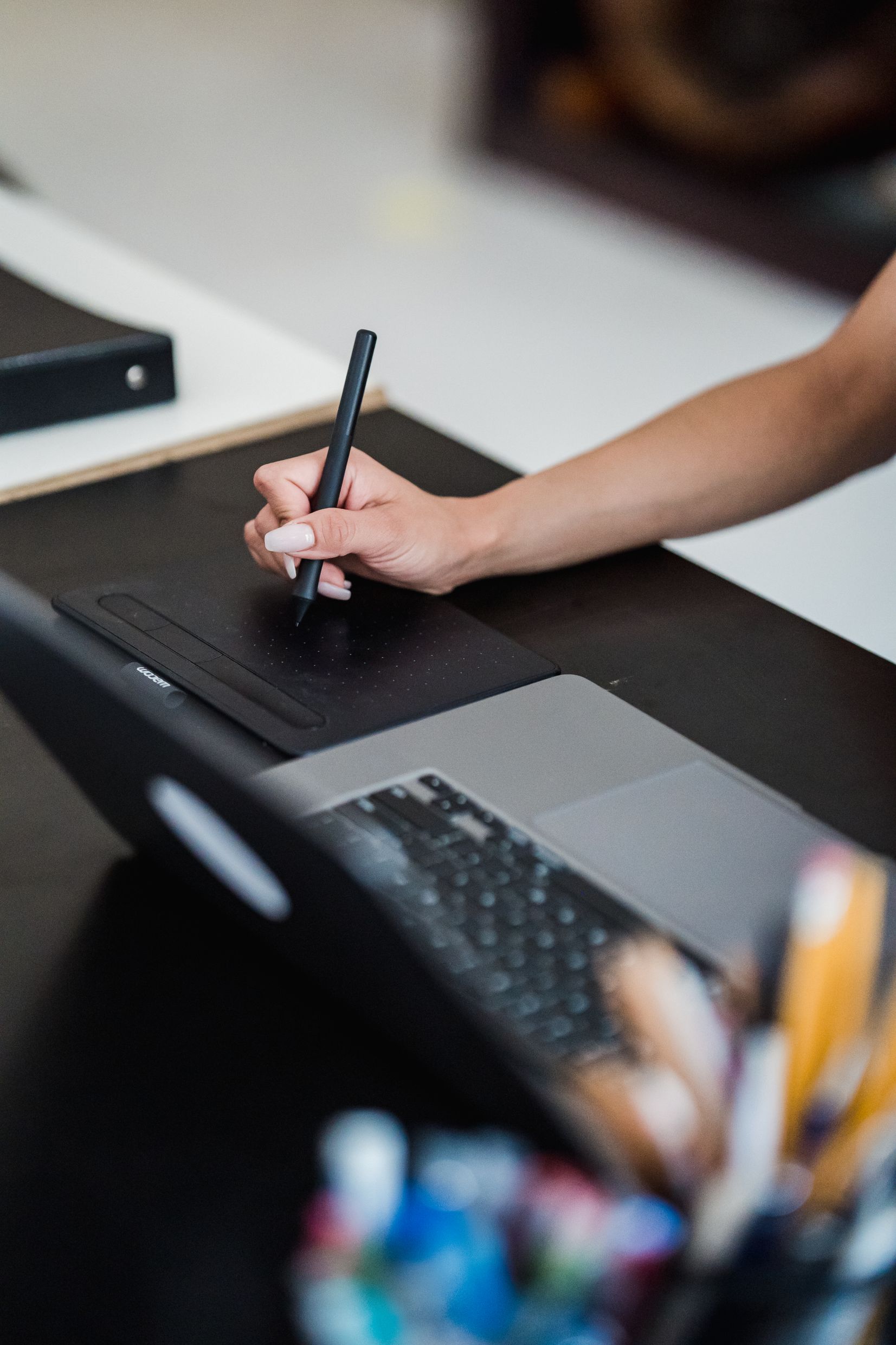 Graphiste travaillant avec une tablette graphique et un ordinateur portable dans un bureau moderne