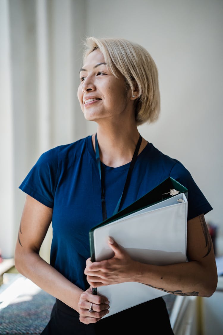 Cheerful Woman Holding Binders