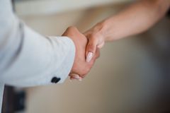 A close-up view of a handshake between two professionals, symbolizing agreement and partnership.
