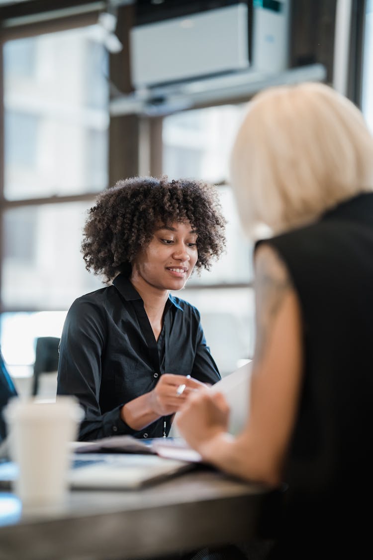 Women Discus Documents In Office