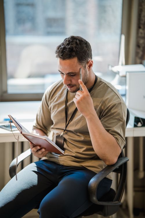 Free Focused man reading notes in a modern office environment. Stock Photo