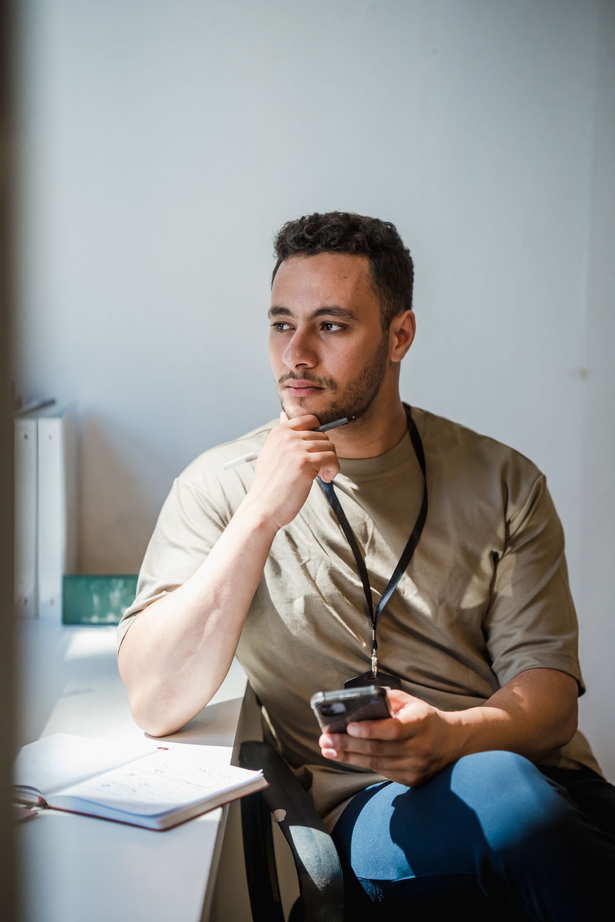 Homem pensativo segurando celular