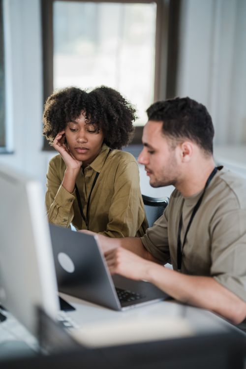 Free Two colleagues collaborating in a modern office setting, engaged in discussion. Stock Photo