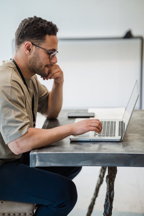 Man Sitting at Desk Working on Laptop