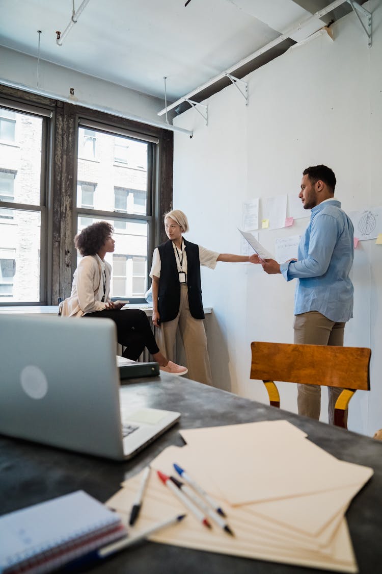 Employees Brainstorming Near Office Board