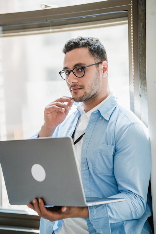 Portrait of Businessman Standing with Laptop 