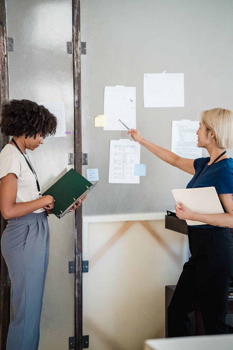 Employees Brainstorm Discussing Papers On Board