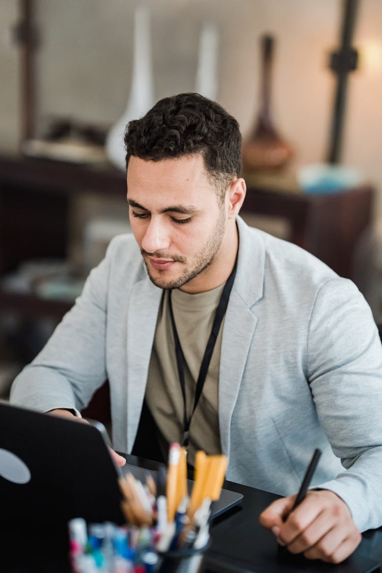 Man Working In Office With Laptop And Professional Tablet