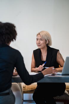Two diverse businesswomen having an engaging meeting in a modern office setting.