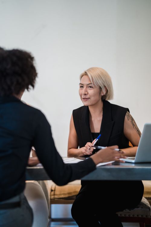 Free Two diverse businesswomen having an engaging meeting in a modern office setting. Stock Photo