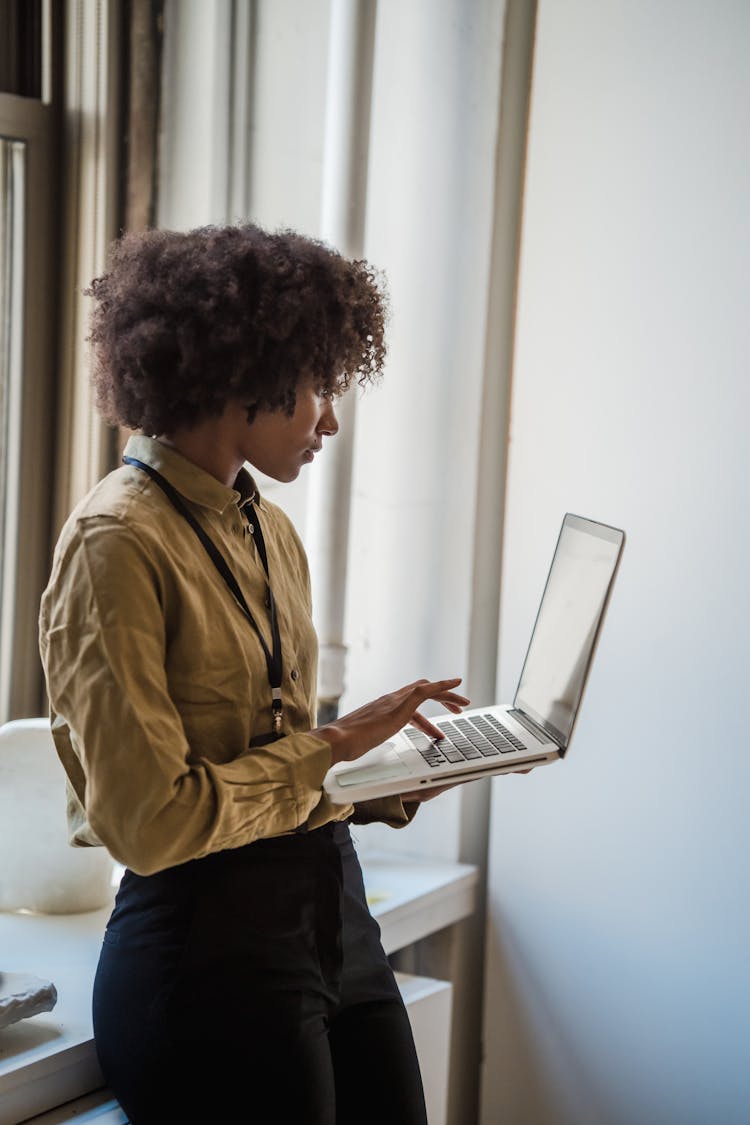 Woman Standing And Typing On Laptop Keyboard