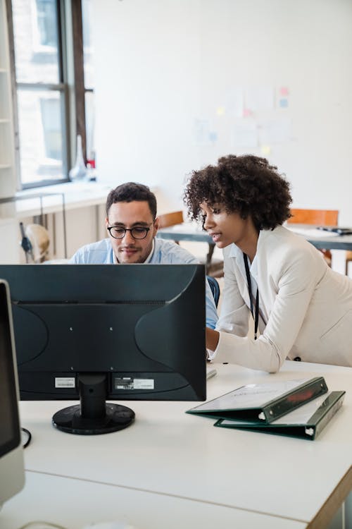 Two Office Colleagues Discussing in Front of Computer Screen 