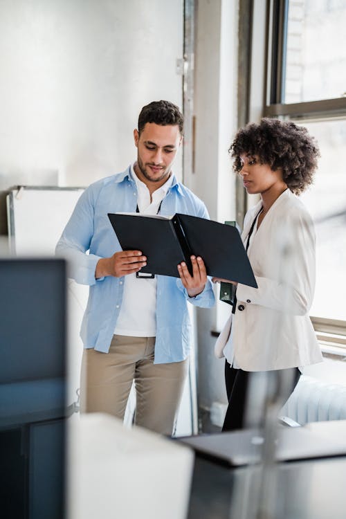 Man and Woman Looking at Files in the Office 