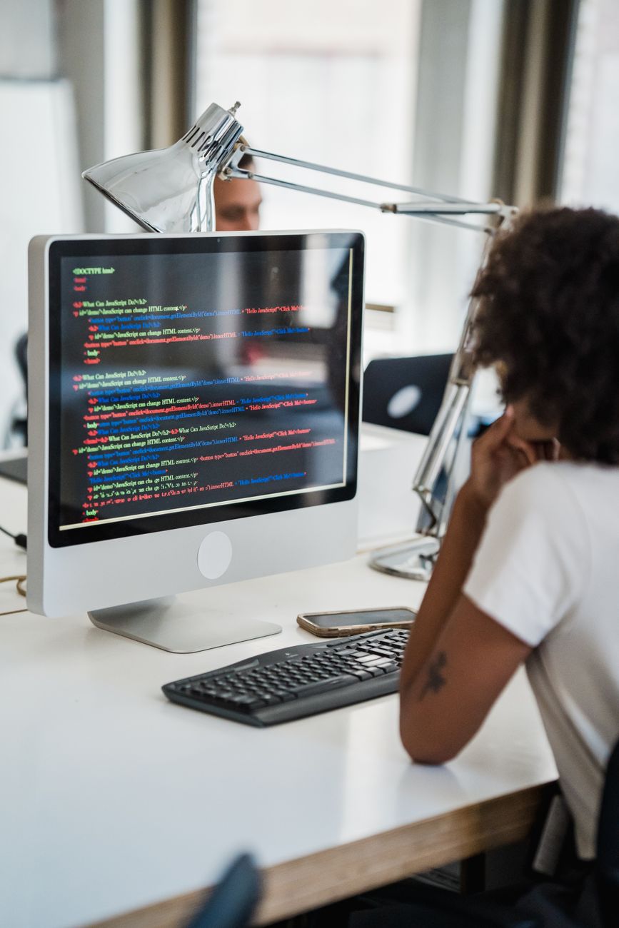 A female professional focused on coding at her desk