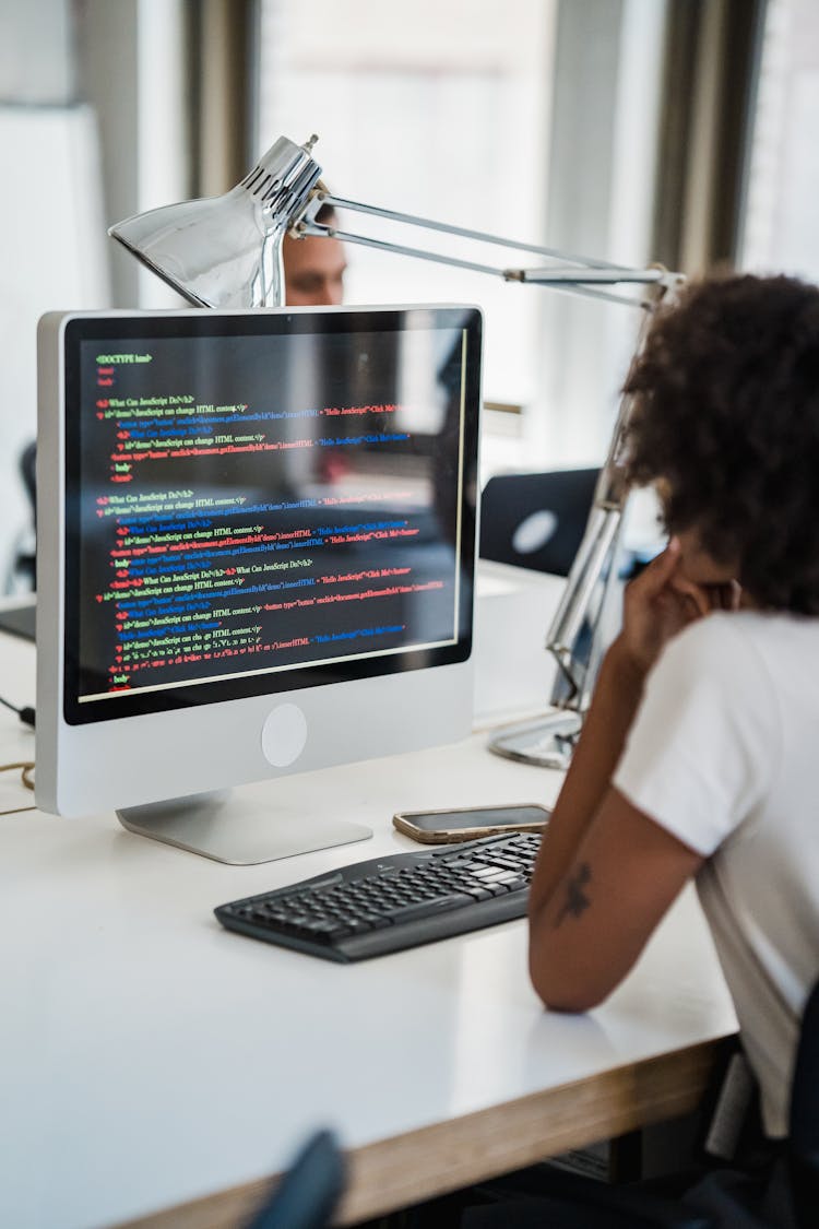 Brunette Woman Working On A Desktop PC In An Office 