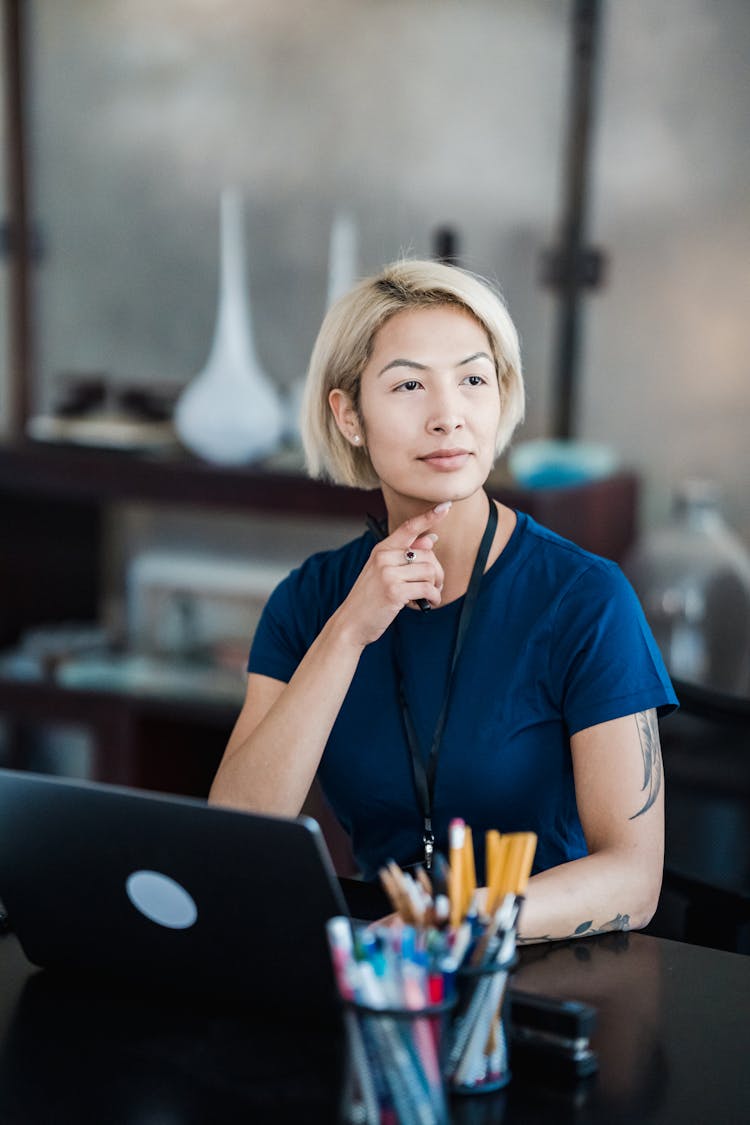 Woman Office Worker Sitting At Desk With Laptop