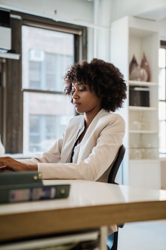 A young professional concentrating at her laptop in a bright contemporary office — photo by Mizuno K on Pexels