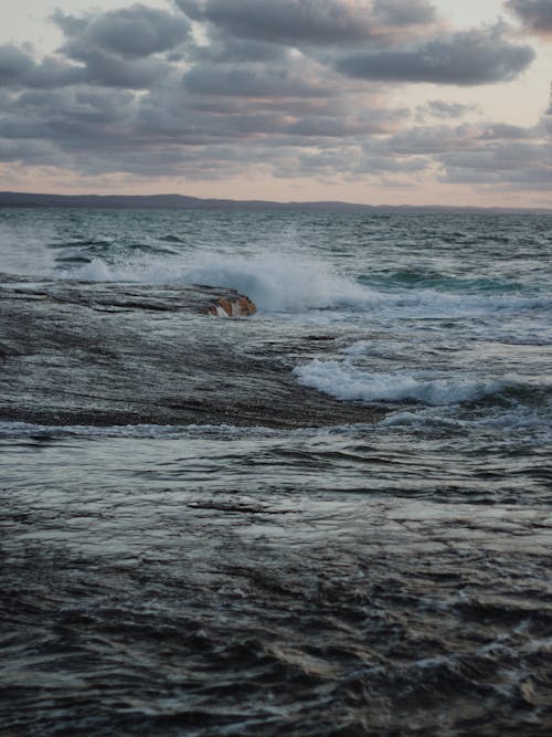 Crashing Ocean Waves under the Cloudy Sky