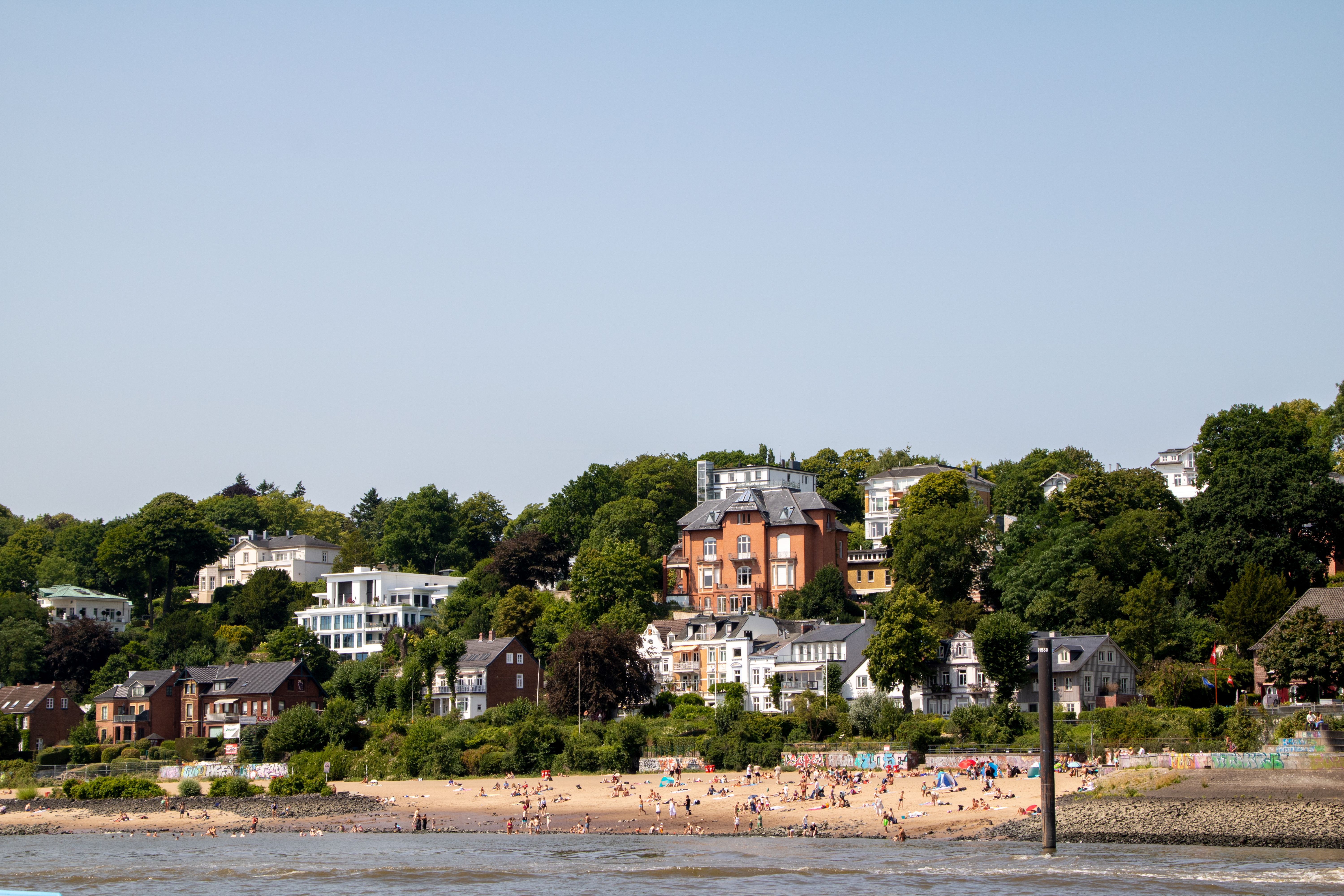 Beautiful panoramic view of beachfront homes and trees in Hamburg on a sunny day.