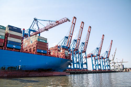 Construction Cranes and Container Ship in Harbor