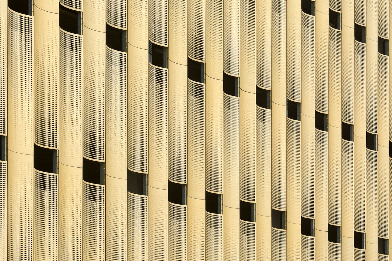 close up of a modern building facade with yellow metallic panels creat