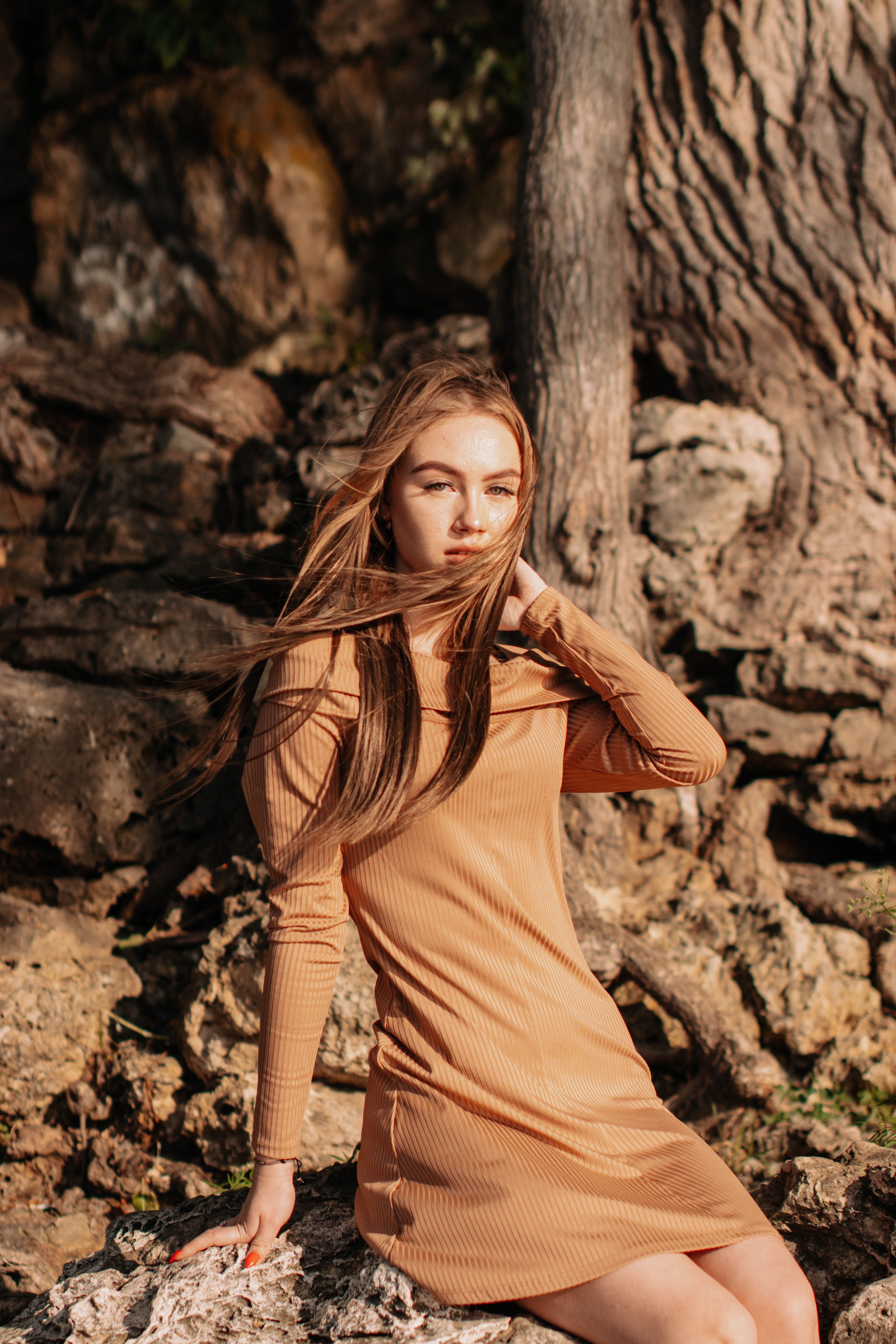Woman in Brown Dress Sitting on a Rock · Free Stock Photo