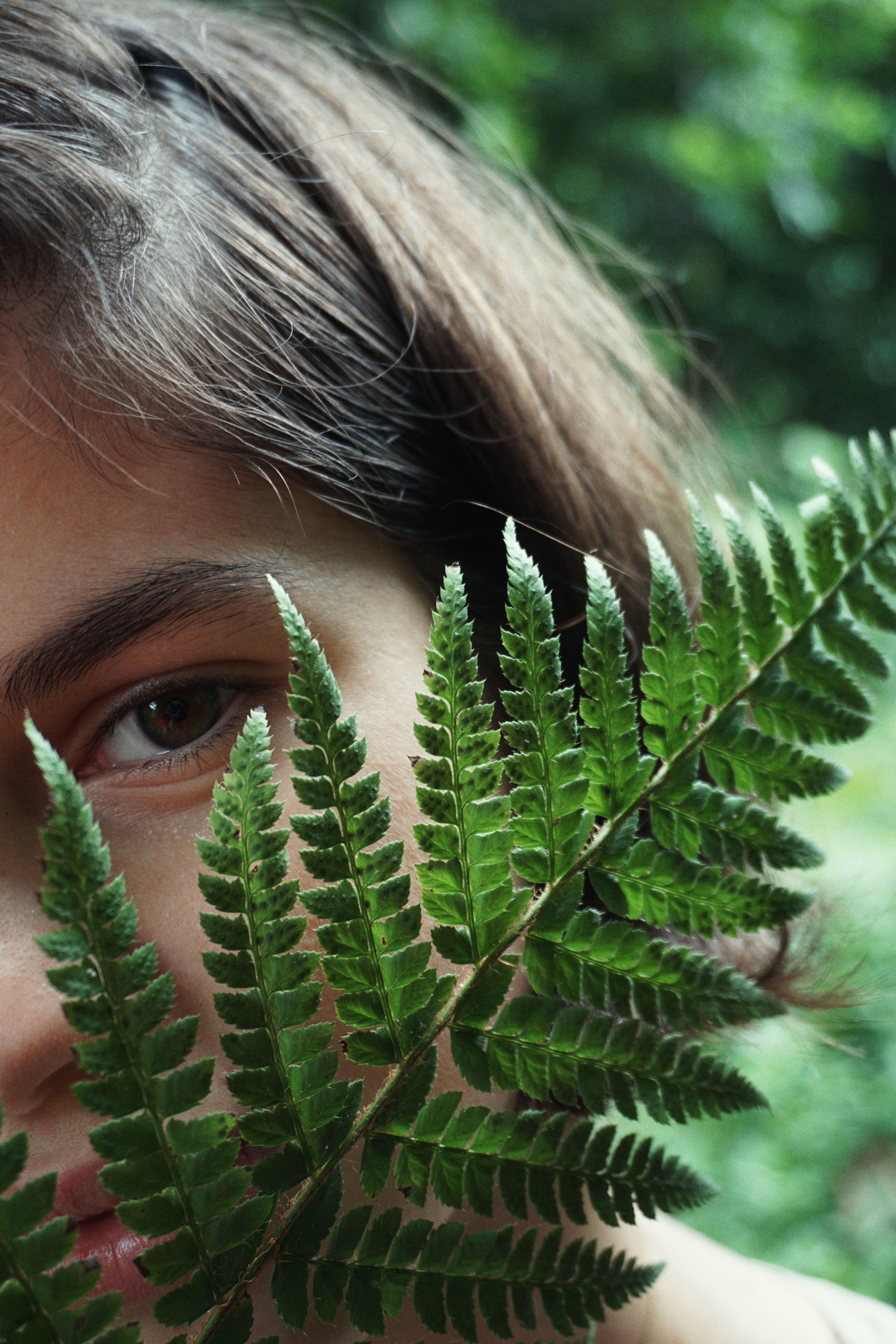 Close-Up Shot of a Girl Holding a Green Fern Plant · Free Stock Photo