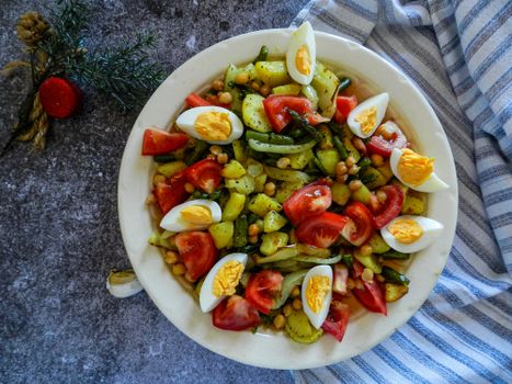 Healthy vegetable salad with chickpeas, tomatoes, and eggs, perfect for a nutritious meal.