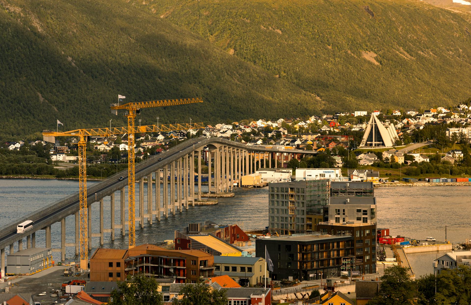 Aerial view of Tromsø Bridge connecting urban and natural landscapes in Norway.