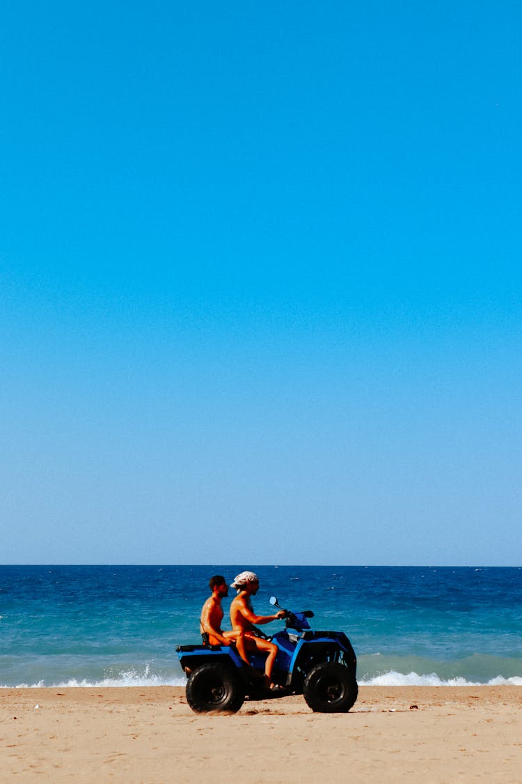 People Driving Through Beach On A Four Wheeler