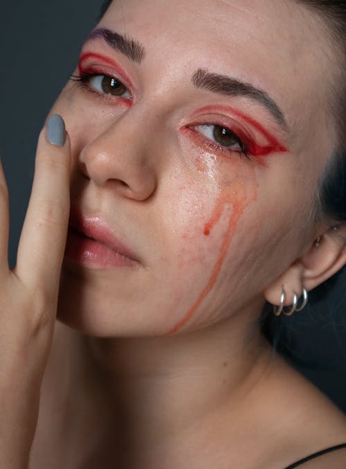 Close Up Photo of Woman with Red Tears